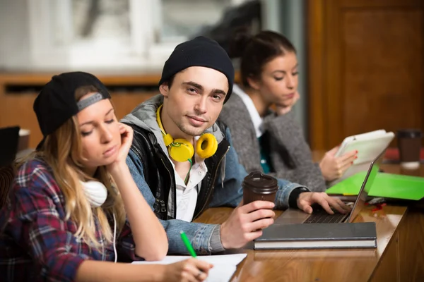 Jovens estudantes sentados em sala de aula — Fotografia de Stock