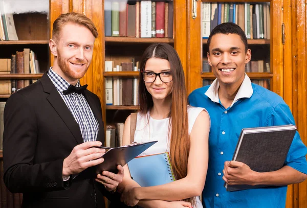 Insegnante e studenti in biblioteca — Foto Stock