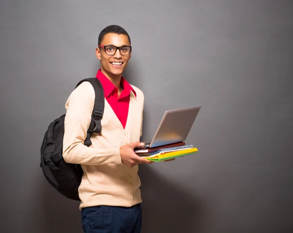 Handsome latin student with laptop computer in studio — Stock Photo, Image