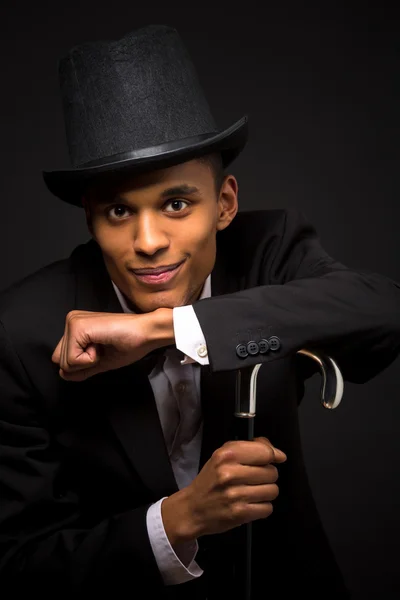 Handsome man in top hat posing with cane — Stock Photo, Image