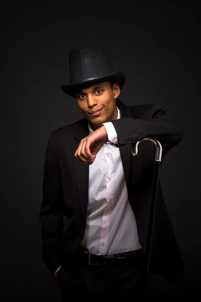 Handsome man in top hat posing with cane — Stock Photo, Image