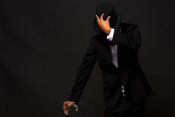 Handsome man in top hat posing with cane — Stock Photo, Image