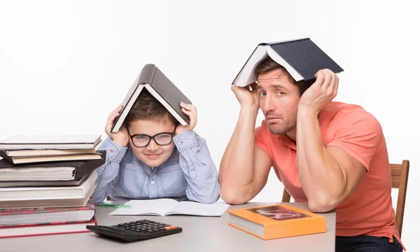 Father and son hiding under books — Stockfoto