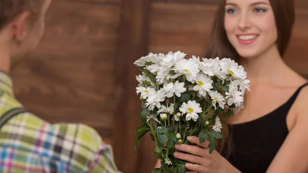 Man presenting his girl-friend beautiful flowers — Stockfoto