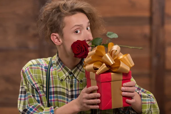 Hipster man holding present and a rose — Stok fotoğraf