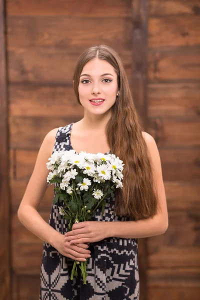 Bella ragazza in posa con mazzo di fiori — Foto Stock