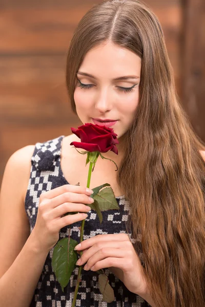 Beautiful girl posing with a red rose — ストック写真