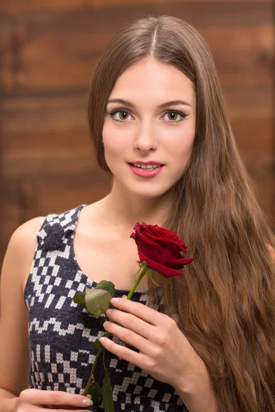 Beautiful girl posing with a red rose — ストック写真