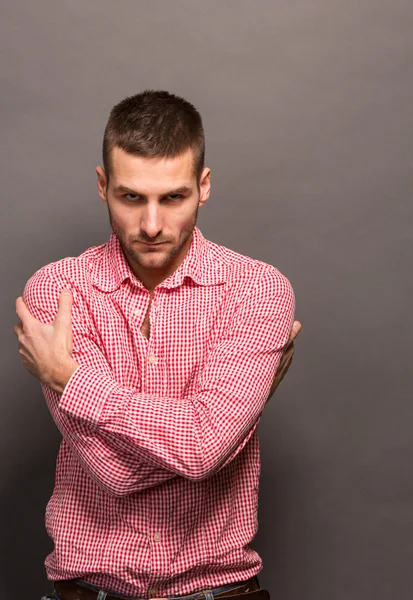 Man hugging himself in studio — Stock Photo, Image