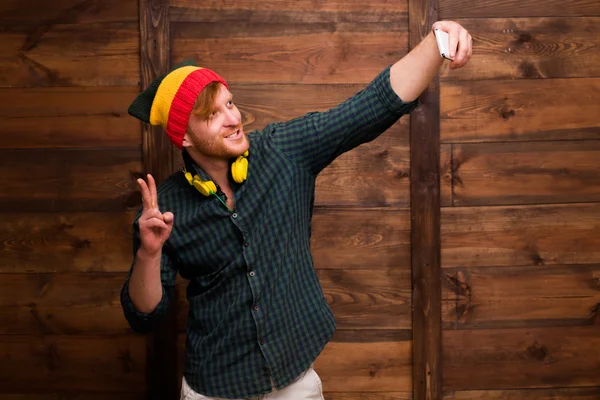Hipster man making selfies over wooden — Stockfoto