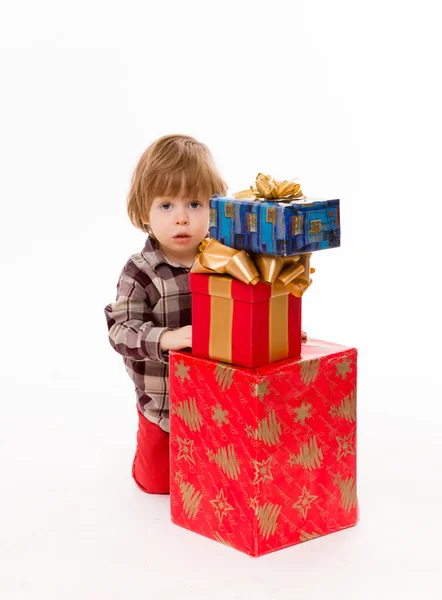 Piccolo bambino nascosto dietro i regali — Foto Stock