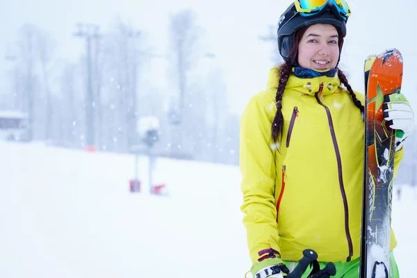 Vrouwelijke skiër permanent met een hemel in de ene hand op achtergrond prachtige berglandschap — Stockfoto