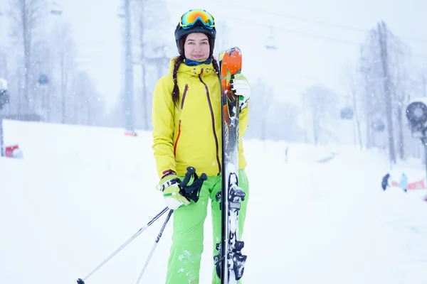 Kobiece narciarz stałego z nieba w jednej ręce tle przepięknej, górskiej scenerii — Zdjęcie stockowe