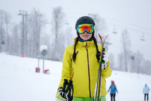Skifahrerin mit Skiern in der einen Hand auf Hintergrund schöne Berglandschaft — Stockfoto