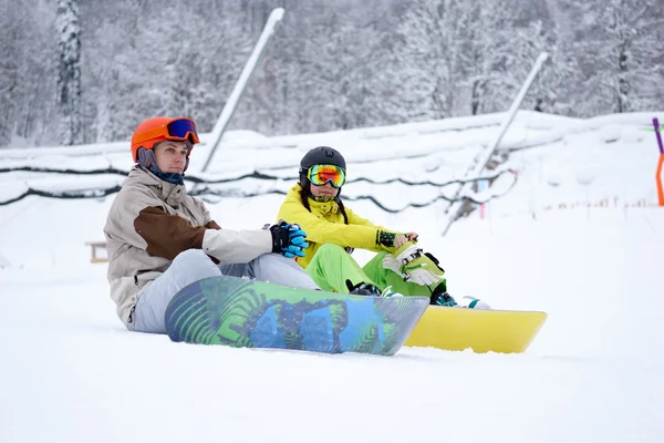 İki snowboard - dağlarda oturan kadın ve erkek — Stok fotoğraf