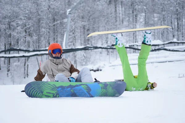 Dva snowboardisté - muži a ženy, sedící v horách — Stock fotografie