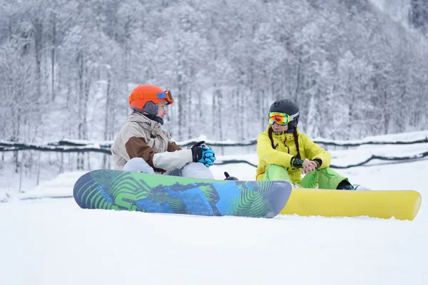 İki snowboard - dağlarda oturan kadın ve erkek — Stok fotoğraf