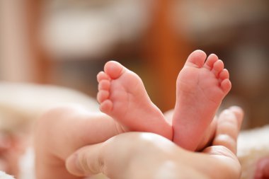 Annesi elinde küçük bir bebek ayak tutar
