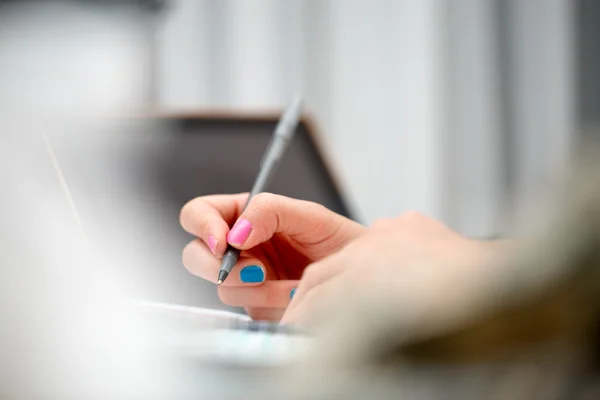 Female hands with pen writing on notebook Stock Photo