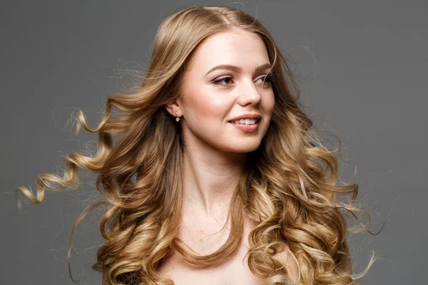 Beautiful woman with long curly hair. Posing at studio. — Stock Photo, Image