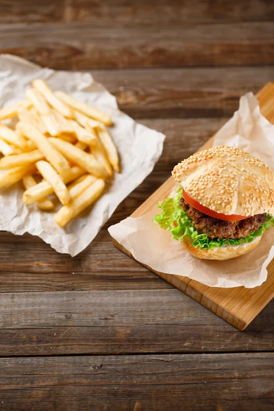 Hamburguesas caseras y papas fritas sobre mesa de madera —  Fotos de Stock