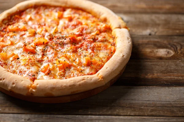 Välsmakande pizza på gamla träbord. — Stockfoto