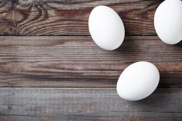 Weiße Eier auf dem alten Holztisch — Stockfoto