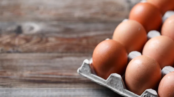 Braune Eier auf einem rustikalen Holztisch — Stockfoto