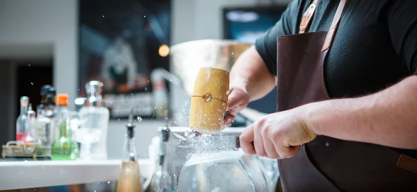 Barman přestávek ledu s dřevěnými kladivo — Stock fotografie