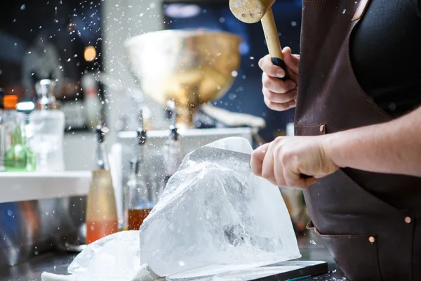 Cantinero manualmente aplastado hielo con martillo de madera y cuchillo de metal . — Foto de Stock
