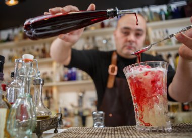 Kokteyl barda cam içine dökme barmen