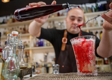 Kokteyl barda cam içine dökme barmen