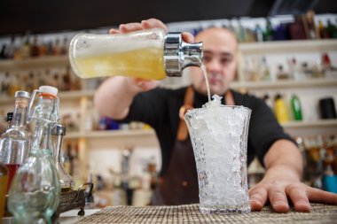 Kokteyl barda cam içine dökme barmen