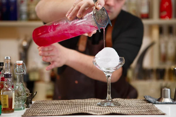 Barman, nalil skleničku růžové koktejlové — Stock fotografie