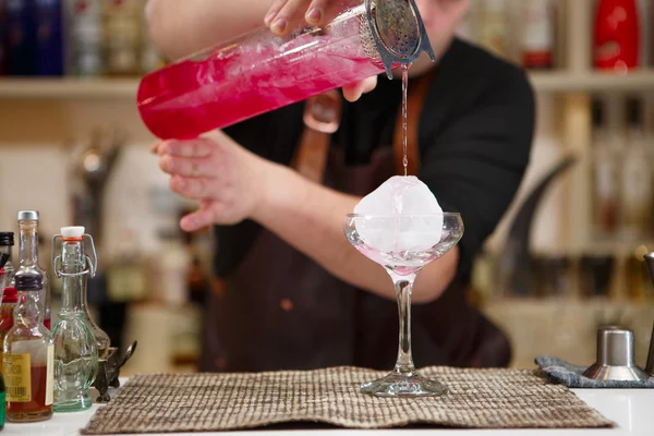 Barman, nalil skleničku růžové koktejlové — Stock fotografie