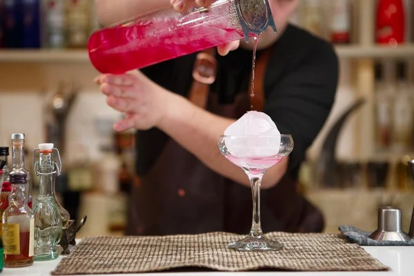 Бармен поливає рожевий коктейльний напій — стокове фото