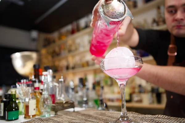 Primer plano de barman mano verter bebida de cóctel rosa en el bar — Foto de Stock