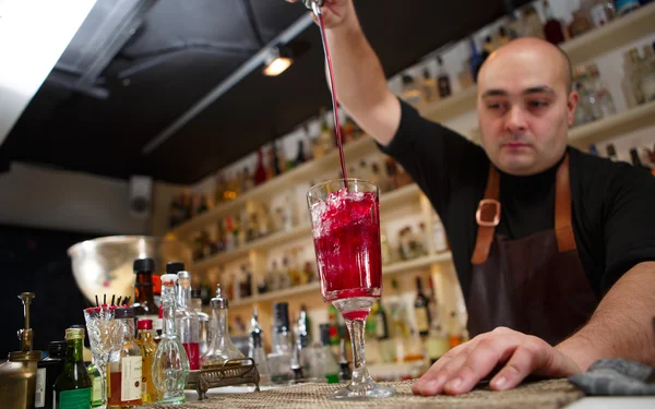 Bartender derramando coquetel vermelho em vidro no bar — Fotografia de Stock
