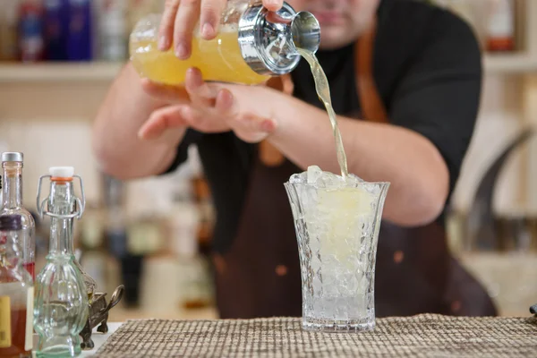 Бармен наливає коктейль у склянку в барі — стокове фото