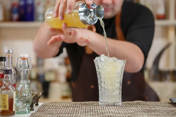 Barkeeper gießt Cocktail in Glas an der Bar — Stockfoto