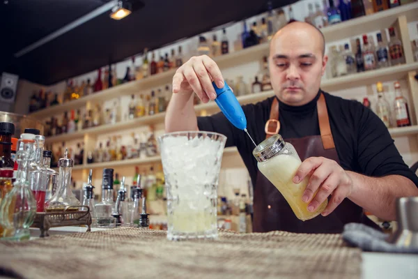 Barman usando una batidora manual para preparar la bebida en el bar o pub — Foto de Stock