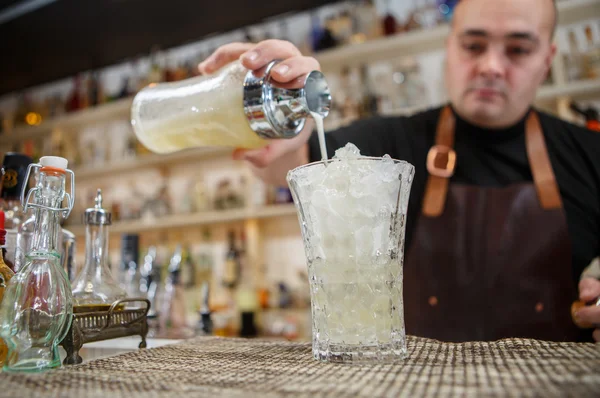 Cantinero vertiendo cóctel en el vaso en el bar — Foto de Stock