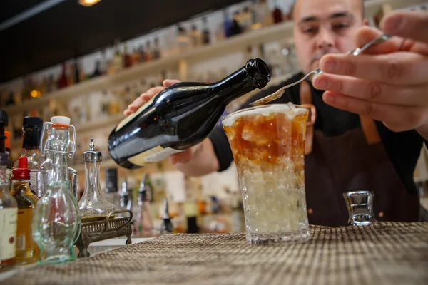 Бармен наливає коктейль у склянку в барі — стокове фото