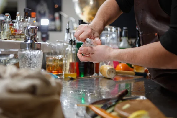 Barkeeper gießt alkoholisches Getränk in kleine Gläser mit Flammen — Stockfoto
