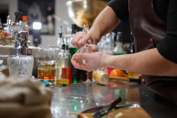 Il barista versa la bevanda alcolica in piccoli bicchieri con fiamme — Foto Stock