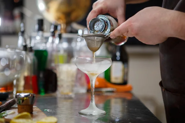 Barman coocks koktejl za bar pult — Stock fotografie