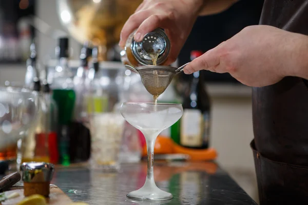 Barman coocks koktejl za bar pult — Stock fotografie