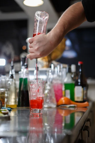 Barman coocks koktejl za bar pult — Stock fotografie