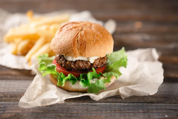 Homemade burger with french fries on wooden table — Stock Photo, Image