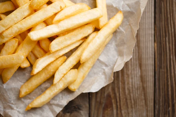 Batatas fritas frescas em fundo de madeira — Fotografia de Stock